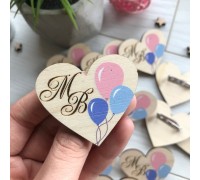 Wooden boutonnieres for a wedding with the initials of the newlyweds.