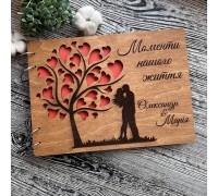 A wooden family photo album with a personalized engraving is a gift for a 5th wedding anniversary.